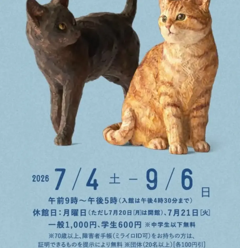 An exhibition notice showing the two carved cat figures, black and orange tabby, side by side above the exhibition dates and admission details.